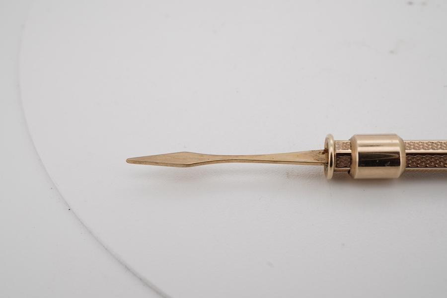 A 9ct gold propelling toothpick, 50mm and a yellow metal propelling pencil.